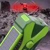 A close-up of a green emergency radio with a solar panel, set against a background of rubble and a red flashing light, suggesting a disaster scenario. Produktbild-Vorschau