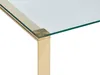 A close-up view of the corner of a glass-top table with a gold-colored stainless steel frame. Náhľad obrázku produktu