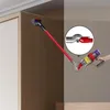 A hand is holding a vacuum cleaner with an adapter attached, demonstrating its use in a tight space. Podgląd zdjęcia produktu