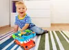 A young boy is playing with a toy steering wheel on a rug in a room. Náhľad obrázku produktu