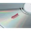 A close-up of a scratched CD or DVD with red fibers from a cleaning brush. Produktbild-Vorschau