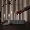 A hand lights a candle in a modern candle holder. Produktbild-Vorschau