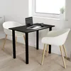 A black table with black legs is set up with a laptop and a mug, next to two white chairs, in a room with a window. Náhľad obrázku produktu