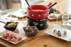 A table setting for a fondue meal with various accompaniments. Produktbild-Vorschau