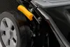 A close-up view of a lawnmower's wheel and adjustment lever. Produktbild-Vorschau