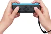 Hands holding a blue and black Nintendo Joy-Con controller. Produktbild-Vorschau