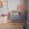 A child's room with a storage unit filled with toys, a stuffed watermelon, and a hula hoop. Produktbild-Vorschau