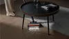 A person is vacuuming the floor under a coffee table with a cordless vacuum cleaner. The vacuum head has LED lights illuminating the dirt on the floor. Produktbild-Vorschau
