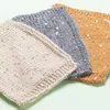 Three knitted swatches with sequins on a light green background. Produktbild-Vorschau