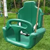 A green child's swing seat with a safety bar is shown in a grassy outdoor setting. Náhled obrázku produktu