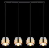 A linear pendant light fixture with four lamps, each with a cylindrical shade. Produktbild-Vorschau