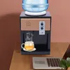 A desktop water dispenser with a cup of tea and a laptop on a wooden desk. Náhled obrázku produktu