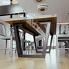 A modern dining room with a wooden table and metal legs, surrounded by chairs. Anteprima dell’immagine prodotto