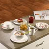 A breakfast setting with Villeroy & Boch tableware, including coffee cups, bowls, and a plate with a pastry, along with jam, granola, and fruit. Náhľad obrázku produktu