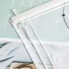 A close-up view of a transparent curtain with a white header and a white pin. The curtain is layered over some documents with text. Produktbild-Vorschau