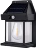 A black outdoor solar wall light with a clear glass lantern and a visible LED bulb inside. Anteprima dell’immagine prodotto
