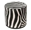 A cylindrical pouffe with a zebra print pattern. Produktbild-Vorschau
