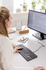 A woman is working at a desk with a computer and keyboard. Náhľad obrázku produktu