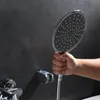A hand holding a shower head over a bathtub. Podgląd zdjęcia produktu