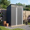 A grey metal garden shed is shown in a backyard setting, with gardening tools and pots nearby. Produktbild-Vorschau
