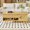 A wooden coffee table with rattan doors is placed in a living room setting, in front of a sofa, on a patterned rug. Voir les images du produit