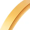 A close-up, angled view of a roll of gold-colored PVC flat profile with adhesive backing. Podgląd zdjęcia produktu