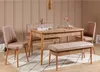 A dining set with a table, chairs, and a bench in a room with a beige wall. Produktbild-Vorschau