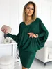 A woman is posing in a green dress, holding a clutch. Anteprima dell’immagine prodotto