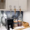 Drei durchsichtige Saugnapfhaken aus Kunststoff, die Küchenutensilien unter einem weißen Schrank halten Anteprima dell’immagine prodotto