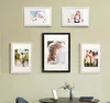 A collection of framed photos displayed on a wall above a table. Produktbild-Vorschau