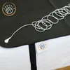 A close-up of an grounding mat with a coiled cord. Produktbild-Vorschau