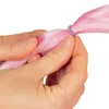 Hands are shown holding and securing a section of pink hair with a purple hair tie. Podgląd zdjęcia produktu