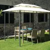 A gazebo with a table and chairs set up on a lawn in front of a stone building. Produktbild-Vorschau