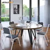 A dining room scene with a round wooden table and chairs, set near large glass doors leading to an outdoor patio. Náhľad obrázku produktu