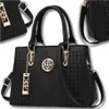 A black women's handbag is displayed against a white background, with a smaller portion of another identical bag visible in the upper left corner. Produktbild-Vorschau