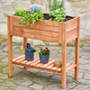A wooden raised garden bed filled with herbs and flowers, placed on a stone patio. Produktbild-Vorschau