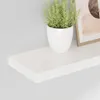 A white floating shelf with a potted plant and a framed picture on it, against a light gray wall. Produktbild-Vorschau