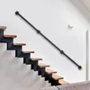 A modern staircase with a black metal handrail mounted on a white wall. Náhled obrázku produktu