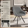 A grey upholstered chair with black metal legs is shown in a room setting, with a text overlay describing its features. Produktbild-Vorschau
