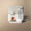 A modern tea machine with a glass of tea and a water reservoir, with dimensions indicated. Produktbild-Vorschau