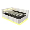 A white upholstered bed frame with a slatted mattress base lifted to reveal storage space underneath. The bed has integrated LED lighting along the headboard and base. Produktbild-Vorschau