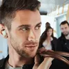 A man wearing earbuds on a bus. Anteprima dell’immagine prodotto
