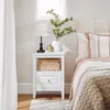 A bedroom scene with a nightstand next to a bed. Náhľad obrázku produktu