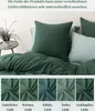 A bed with dark green bedding and pillows, with a small table and plant on the side. Below are swatches of the fabric in different lighting conditions. Produktbild-Vorschau