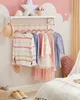 A child's bedroom with clothes hanging on a rack. Náhled obrázku produktu