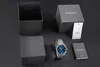 A watch and its packaging are laid out on a dark surface. Produktbild-Vorschau