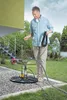 A man is setting up a submersible pump in a garden next to a house. Anteprima dell’immagine prodotto