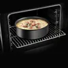 A round cake pan with a baked dish inside is placed on a rack inside an oven. Anteprima dell’immagine prodotto