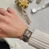 A close-up of a person's hand wearing a silver Casio watch and a beaded bracelet, with a small bouquet of dried flowers in the background. Produktbild-Vorschau
