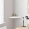 A white corner shelf mounted on a wall, with a few decorative items on it. Voir les images du produit